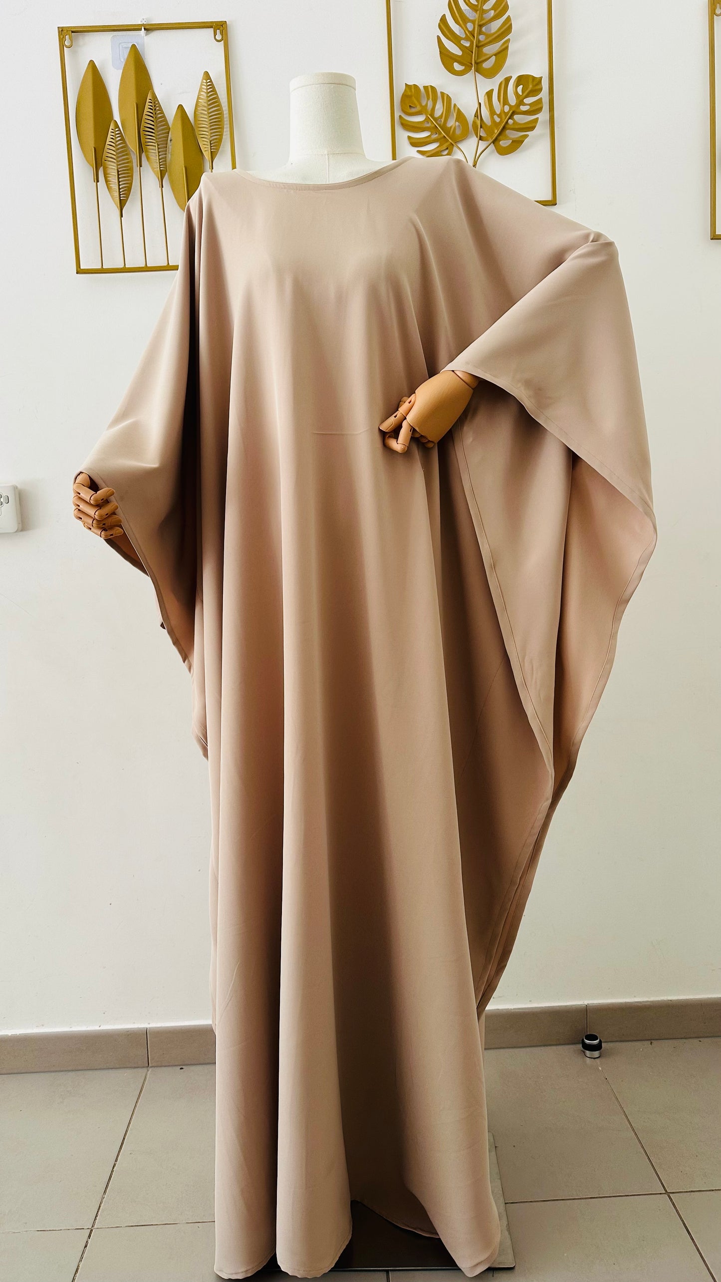 Robe longue Malia en crêpe lin de haute qualité, coupe fluide avec manches longues style cape, portée par mannequin femme. Taille unique ajustable grâce à des liens intérieurs. Couleur : beige / bleu marine / marron.