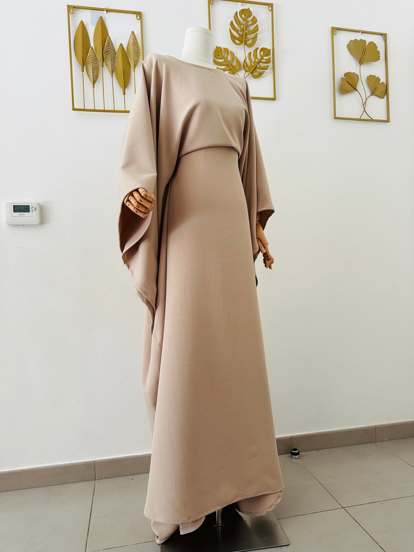 Robe longue Malia en crêpe lin beige, manches longues style cape, taille unique ajustable grâce à des liens intérieurs. Matière fluide et élégante, longueur au sol.