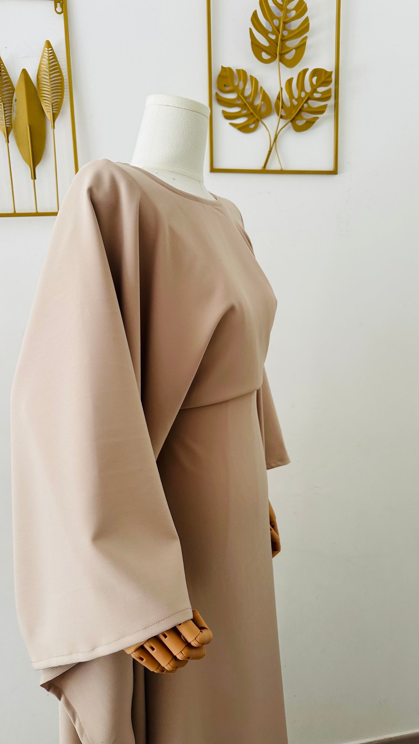 Robe longue Malia en crêpe lin beige, manches longues style cape, taille unique ajustable grâce à des liens intérieurs. Matière fluide et élégante, longueur au sol.