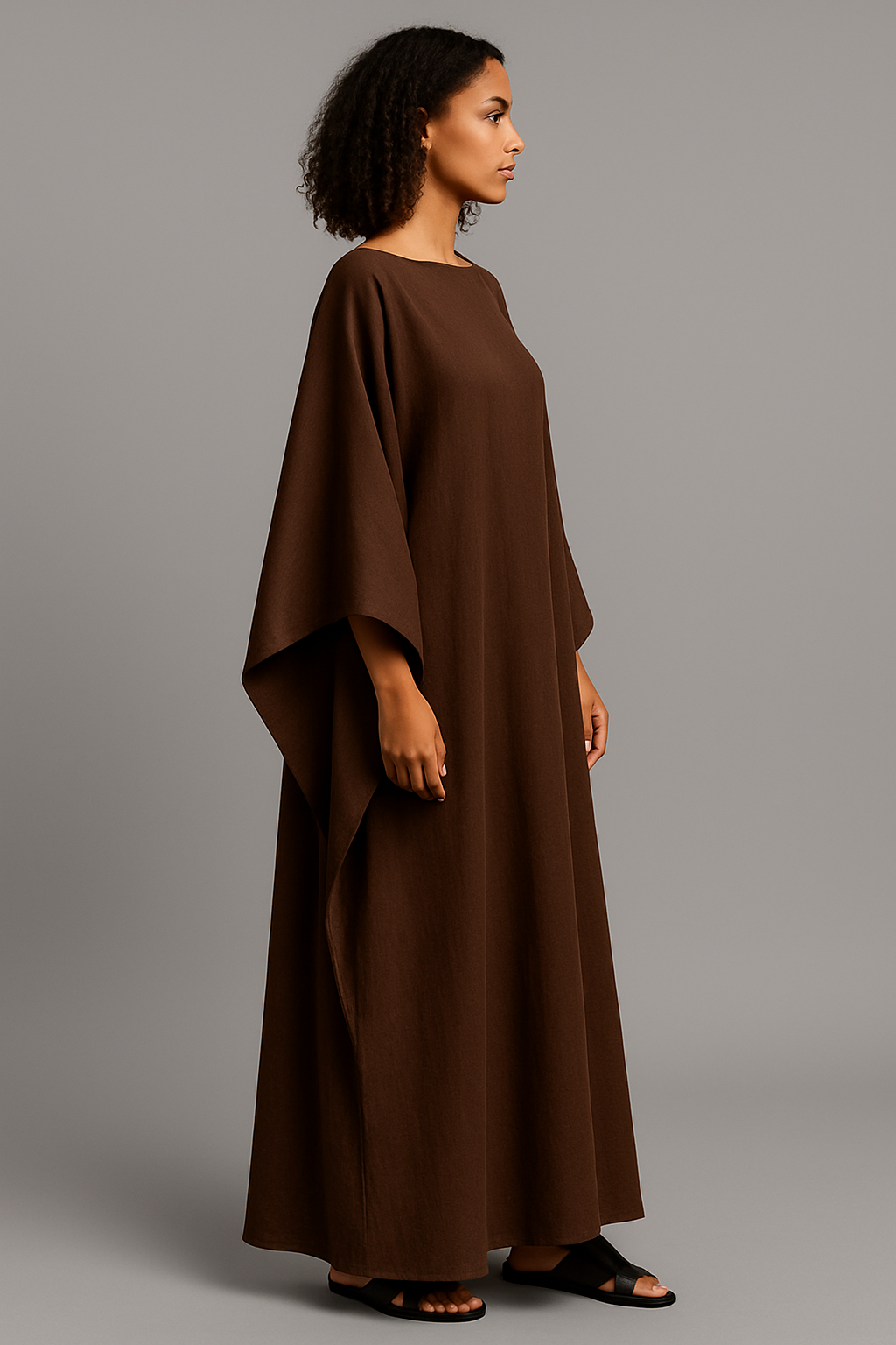 Robe Malia marron chocolat en crêpe lin, longue, fluide, avec manches cape. Taille unique ajustable. Élégante, idéale pour l’été ou des occasions spéciales.
