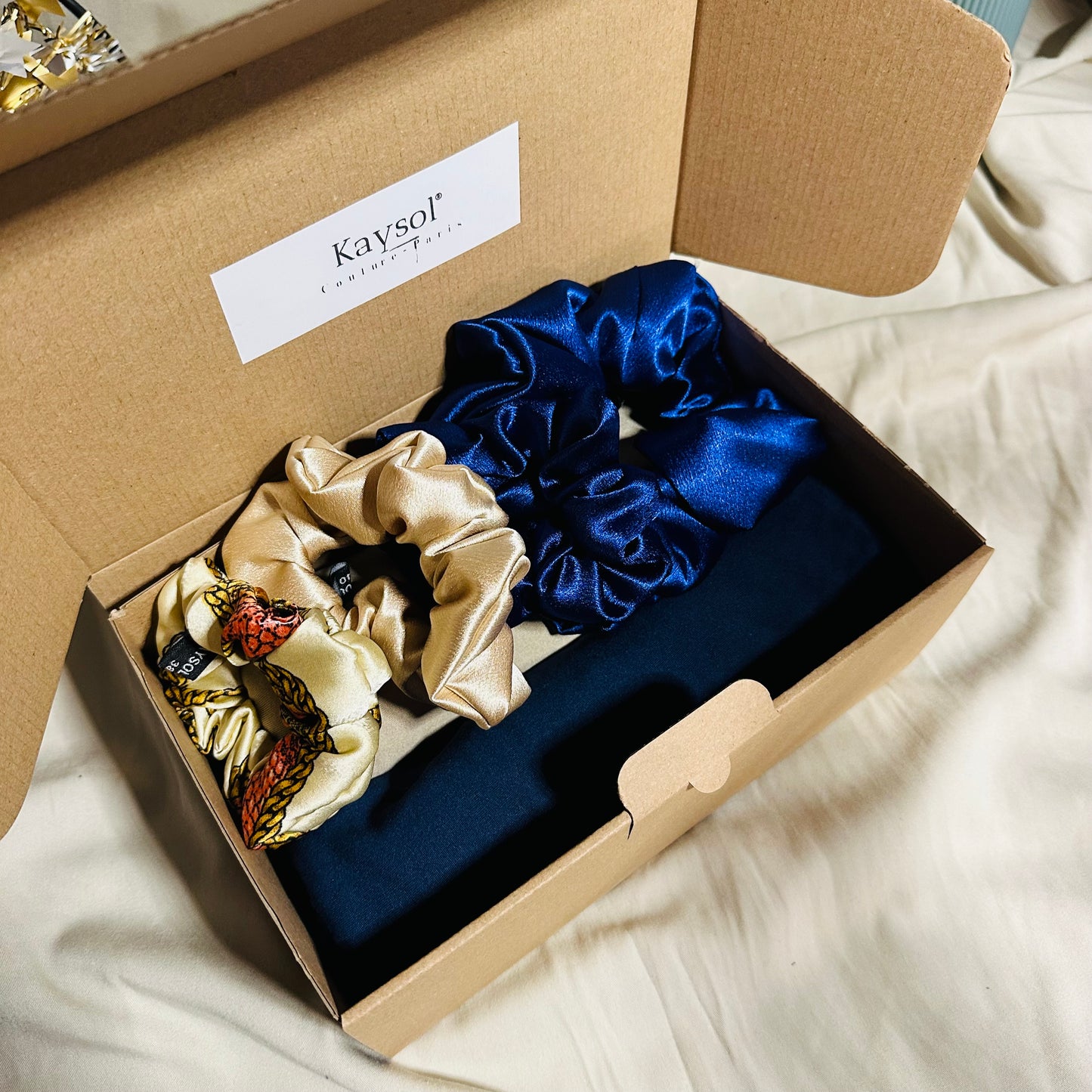 Coffret cadeau femme comprenant deux foulards en jersey beige et marine avec lot de chouchous en satin premium assortis.