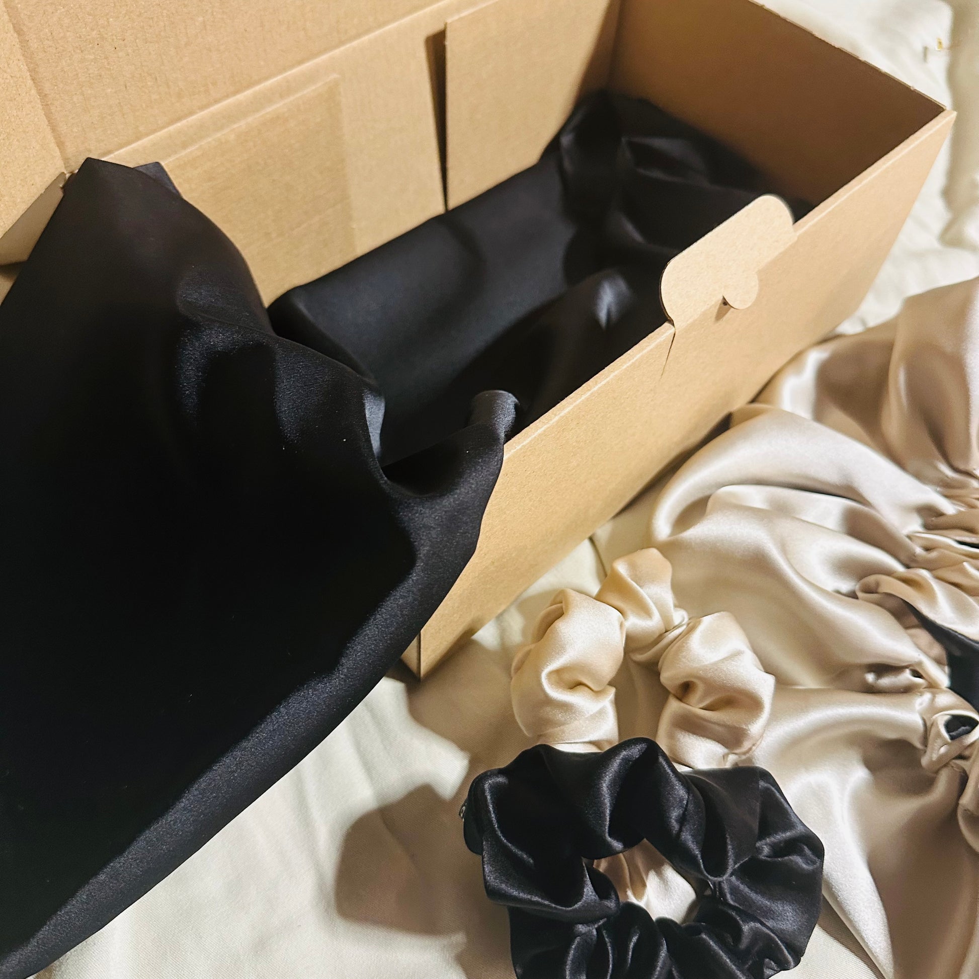 Coffret soie de mûrier noir beige avec taie 22 mommes, bonnet 19 mommes et deux chouchous assortis.