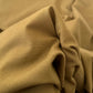 Gabardine 100 % coton kaki clair vendue au mètre. Tissu dense et résistant (240 g/m²), idéal pour pantalons, vestes et projets couture.