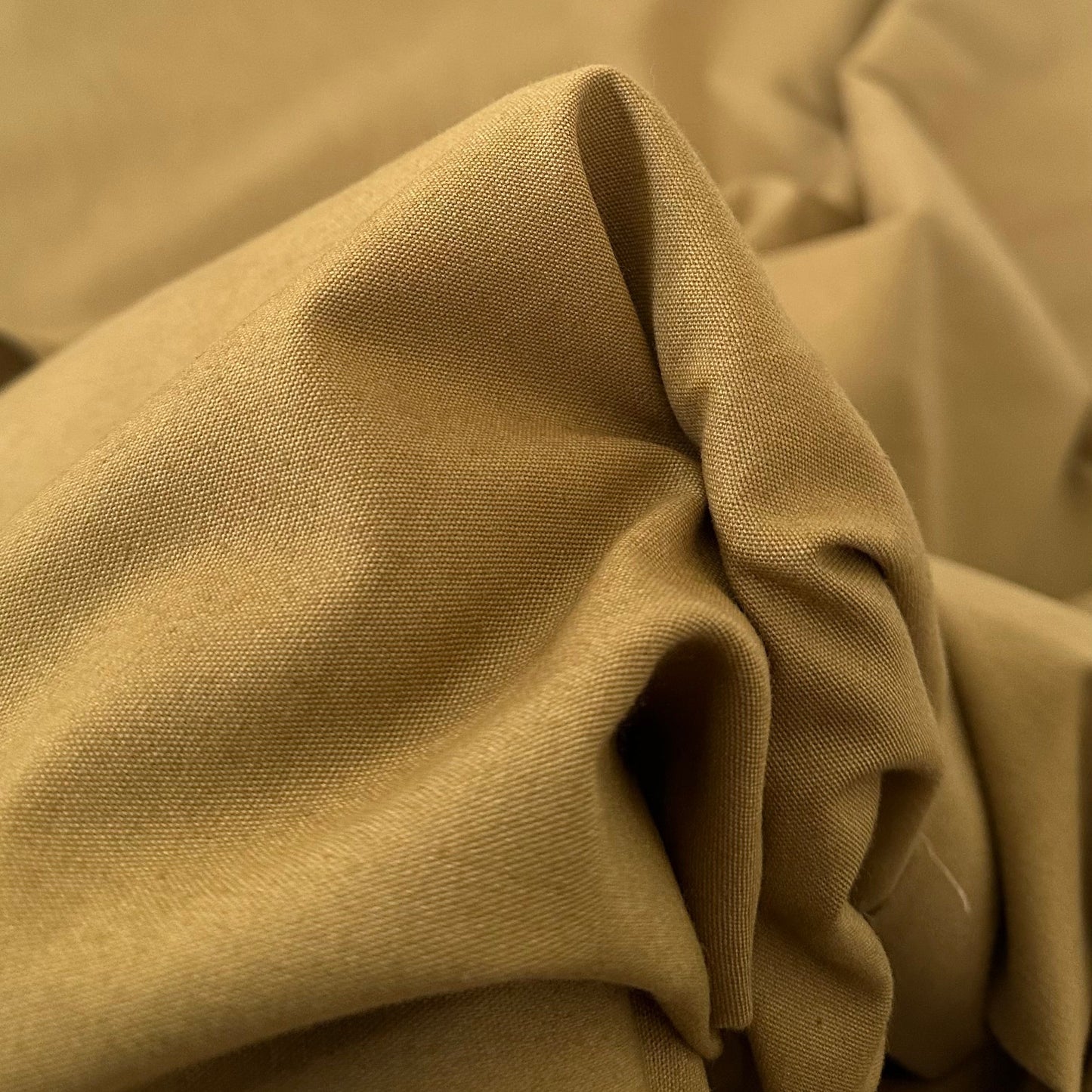 Gabardine 100 % coton kaki clair vendue au mètre. Tissu dense et résistant (240 g/m²), idéal pour pantalons, vestes et projets couture.