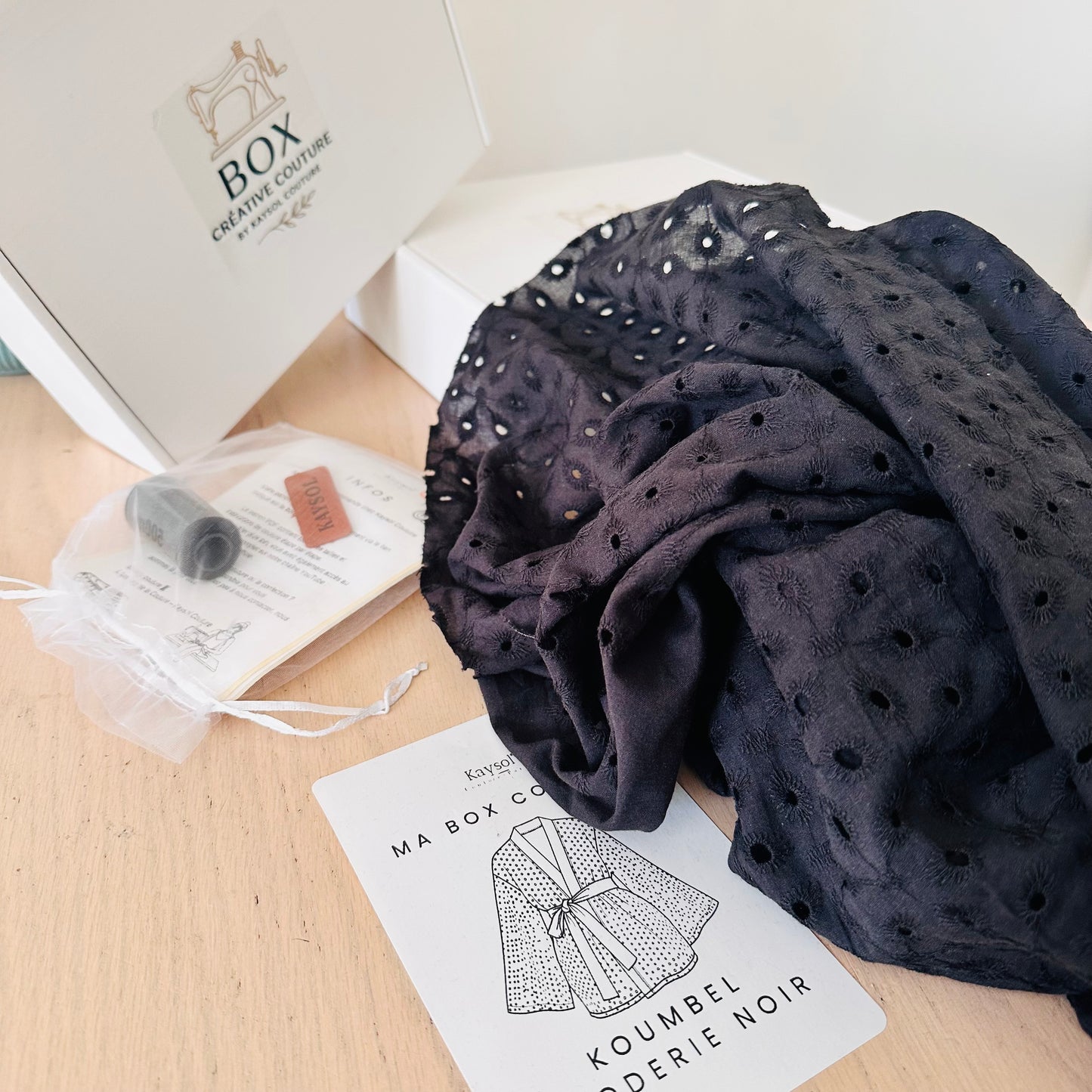 Cousez le kimono KOUMBEL en broderie anglaise noire 100% coton. Box complète avec tissu, patron du 34 au 56, accessoires et vidéo tutorielle.