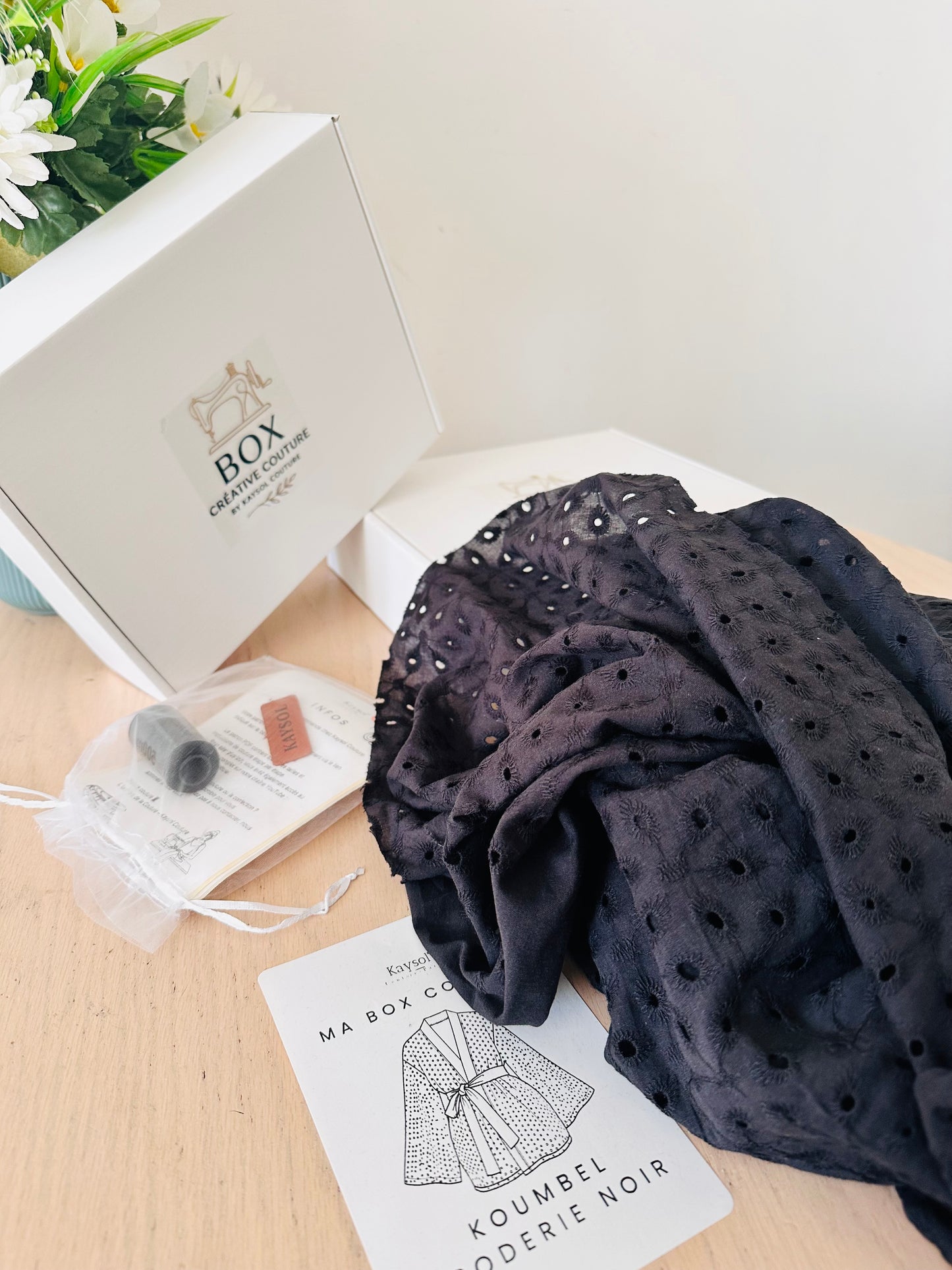 Cousez le kimono KOUMBEL en broderie anglaise noire 100% coton. Box complète avec tissu, patron du 34 au 56, accessoires et vidéo tutorielle.