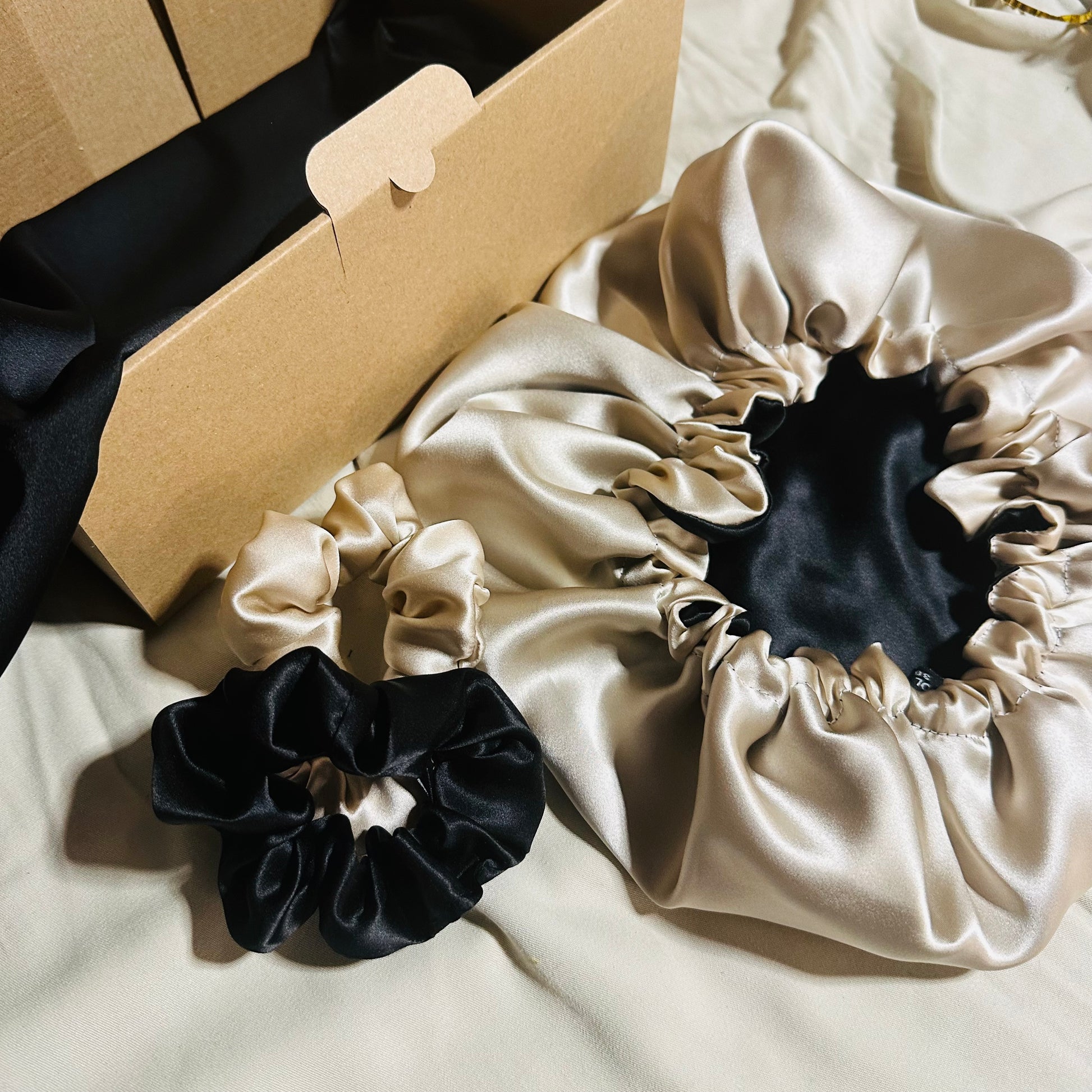Coffret soie de mûrier noir beige avec taie 22 mommes, bonnet 19 mommes et deux chouchous assortis.