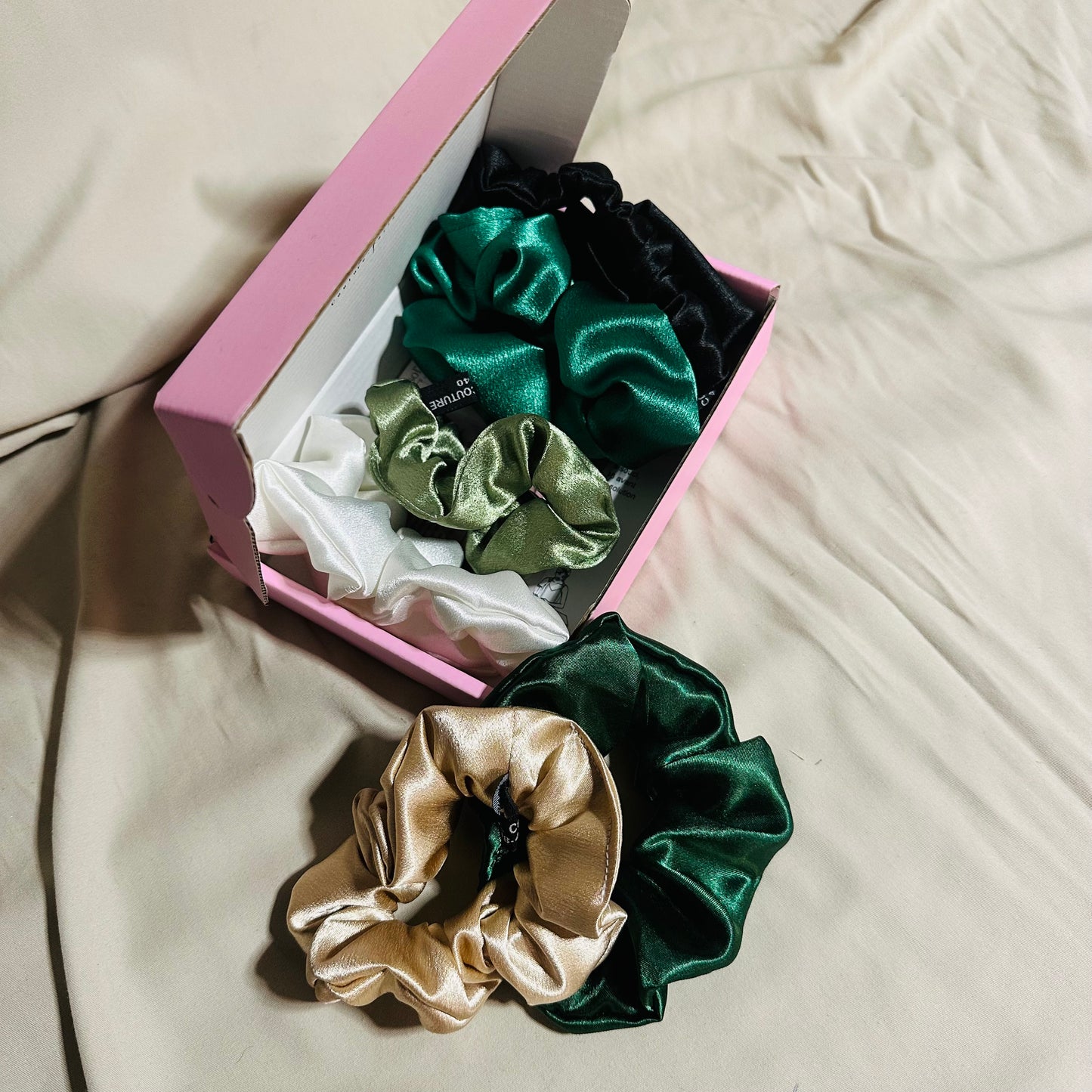 Coffret de 6 chouchous en satin premium, nuances vert et doré. Protège les cheveux, limite la casse et sublime vos coiffures. Livraison internationale.