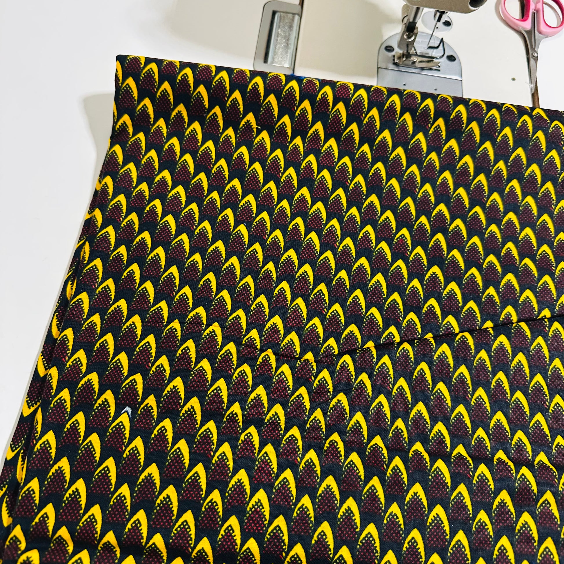 Tissu Wax africain, motif écailles jaunes et bordeaux sur fond noir – coupon 3 yards.