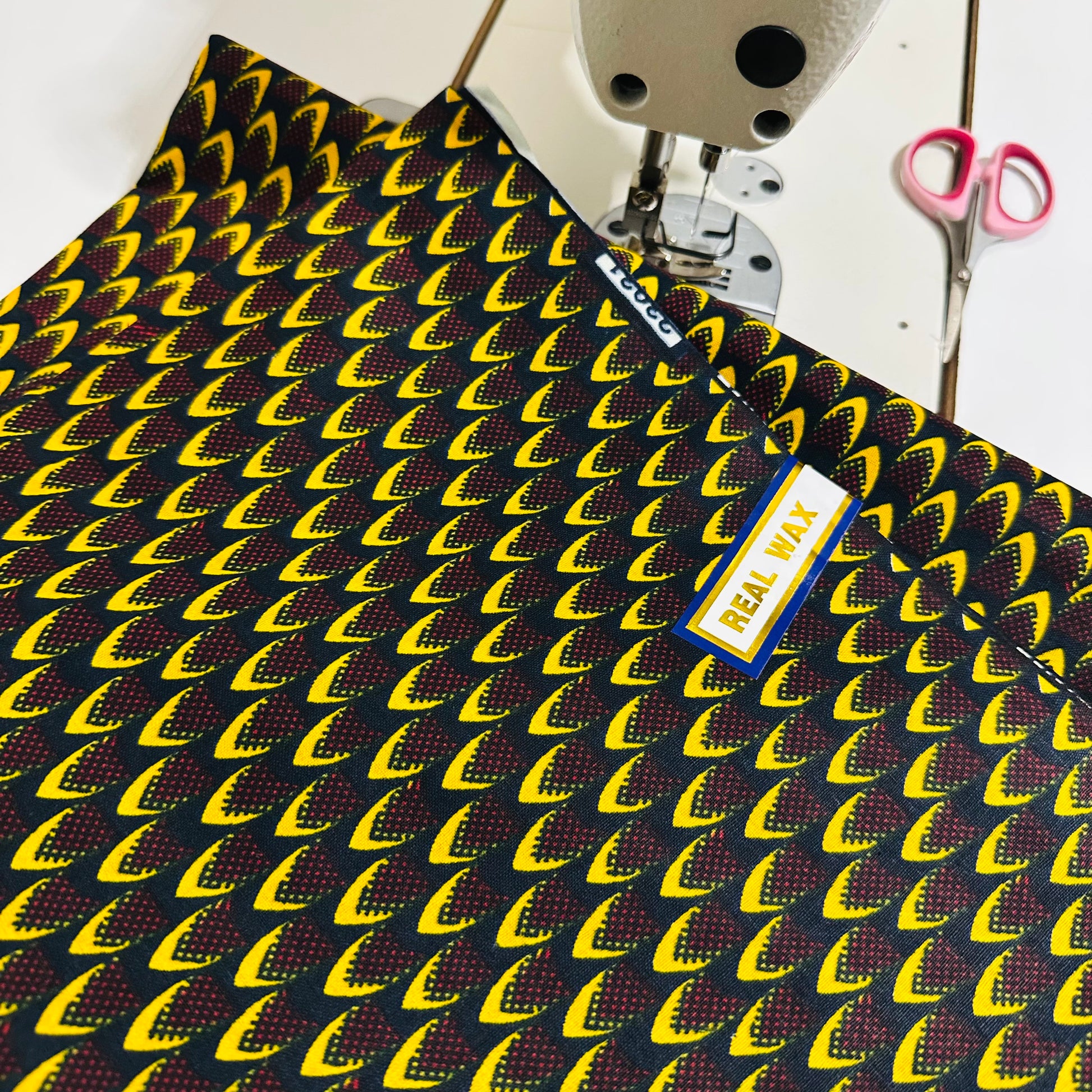 Tissu Wax africain, motif écailles jaunes et bordeaux sur fond noir – coupon 3 yards.