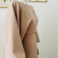 Robe longue Malia en crêpe lin beige, manches longues style cape, taille unique ajustable grâce à des liens intérieurs. Matière fluide et élégante, longueur au sol.
