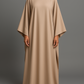 Robe longue Malia en crêpe lin beige, manches longues style cape, taille unique ajustable grâce à des liens intérieurs. Matière fluide et élégante, longueur au sol.