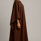 Robe Malia marron chocolat en crêpe lin, longue, fluide, avec manches cape. Taille unique ajustable. Élégante, idéale pour l’été ou des occasions spéciales.
