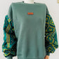 Sweat femme vert manches batik Bogolan pailleté. Pièce unique et stylée signée Kaysol Couture. Cadeau idéal, confort et inspiration wax.