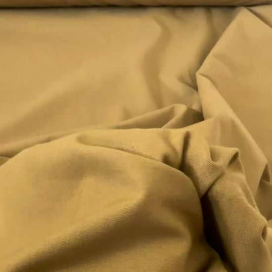 Gabardine 100 % coton kaki clair vendue au mètre. Tissu dense et résistant (240 g/m²), idéal pour pantalons, vestes et projets couture.