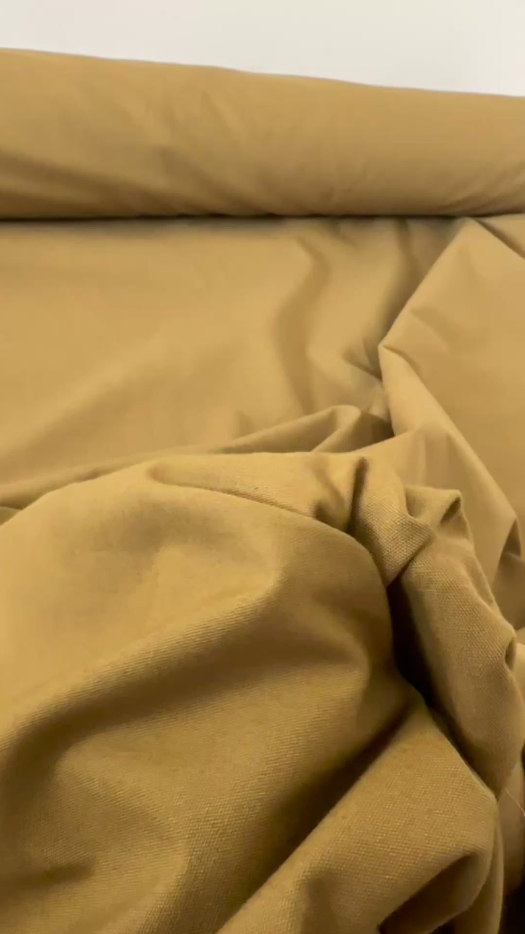 Gabardine 100 % coton kaki clair vendue au mètre. Tissu dense et résistant (240 g/m²), idéal pour pantalons, vestes et projets couture.