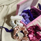 Coffret 6 chouchous en satin premium nuance girly comprenant blanc, nude, rose, violet et bordeaux, taille moyenne.